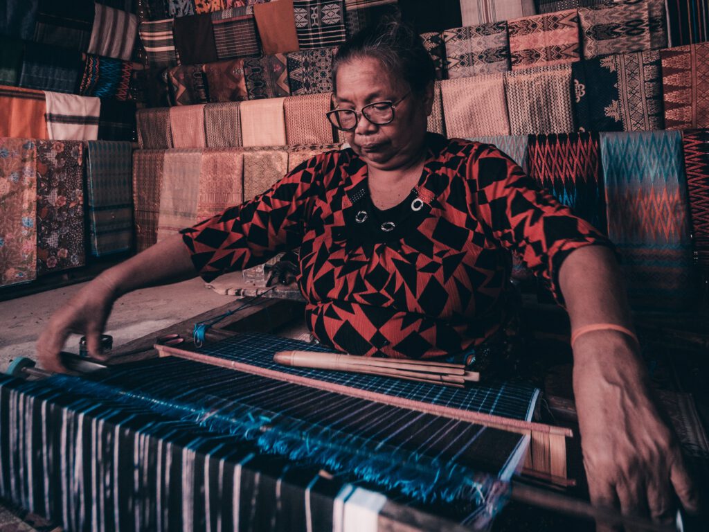 A woman doing Sasak weaving art in traditional way.